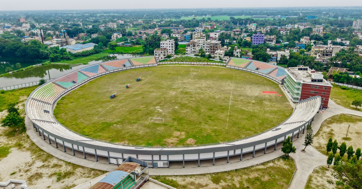 Aerial view of an expansive football stadium with surrounding cityscape