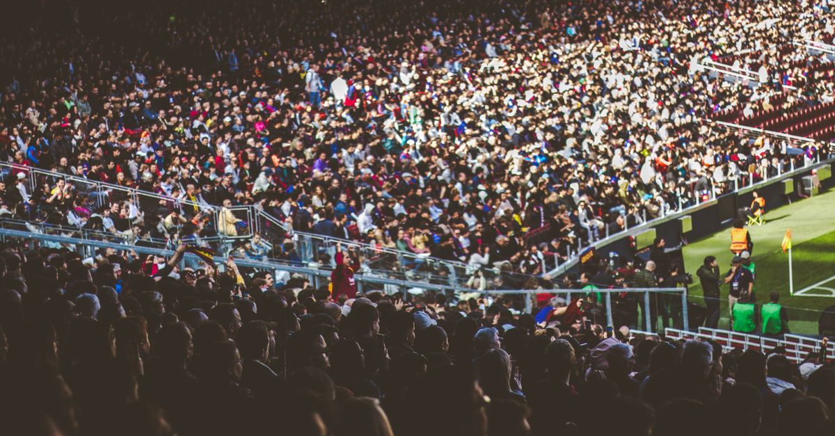 A crowded soccer stadium packed with enthusiastic fans during a match.